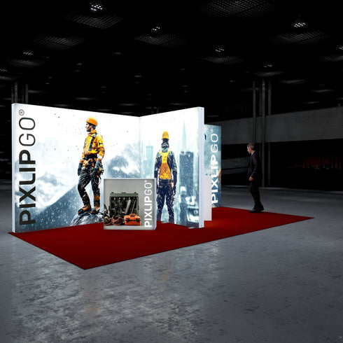 A side-angle view of the Pixlip GO booth highlighting its high-adventure theme. The panels show close-ups of mountaineers braving extreme conditions, while a counter with detailed tool imagery emphasizes functionality. A visitor approaches the display on the red-carpeted floor.