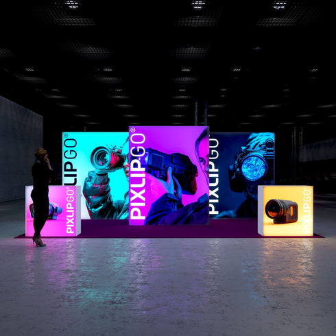 A frontal view of the exhibition booth, showcasing illuminated displays with bold images of people using advanced photography and surveillance equipment. The booth is highlighted by vibrant neon colors of blue, purple, and orange, creating a striking and modern visual appeal.