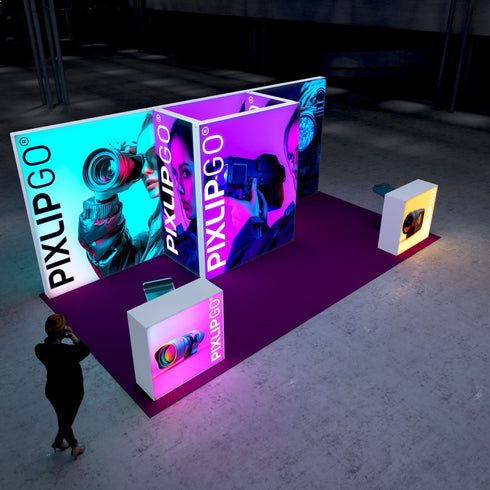 A dynamic exhibition stand featuring vibrant illuminated displays with images of individuals using high-tech cameras and equipment. The central focus is on a professional woman holding a video camera, surrounded by bright blue and pink lighting, creating a futuristic ambiance.
