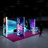 A side view of the exhibition stand, highlighting the depth of the illuminated displays. The combination of vibrant colors and modern design conveys a professional and forward-thinking image. A man stands in front of the stand, observing the presentation.