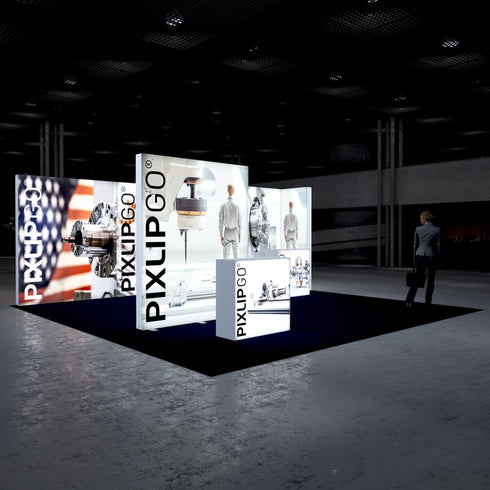 A rear-side perspective of the PIXLIPGO exhibition setup, highlighting illuminated graphic panels of industrial machines and gears with a sleek, minimalist design against a dark background. A visitor walks nearby.
