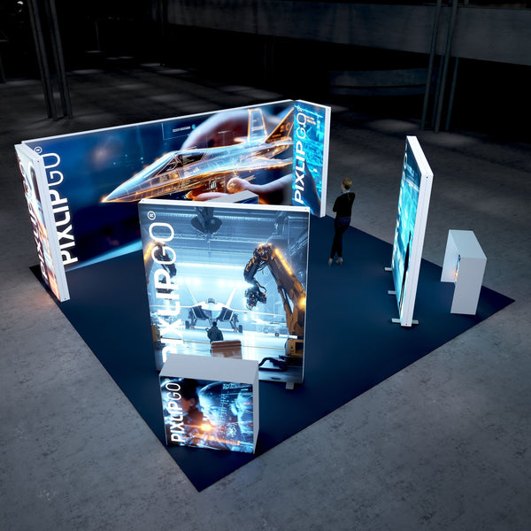 A high-tech trade show booth featuring a futuristic jet design on illuminated panels. The booth showcases robotic arms working in a manufacturing setting and interactive technological displays on the panels. A visitor is walking by, observing the setup.