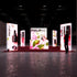A frontal view of the exhibition booth with vibrant pink flower graphics, showcasing cosmetic products such as droppers and bottles. The PIXLIP GO branding is prominent on all lit panels, while the floor is a deep red carpet.