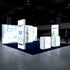 A spacious trade show booth with illuminated PIXLIP GO displays featuring medical and laboratory themes. The booth includes lighted counters and tall panels, creating a modern and clean design on a navy blue carpet.